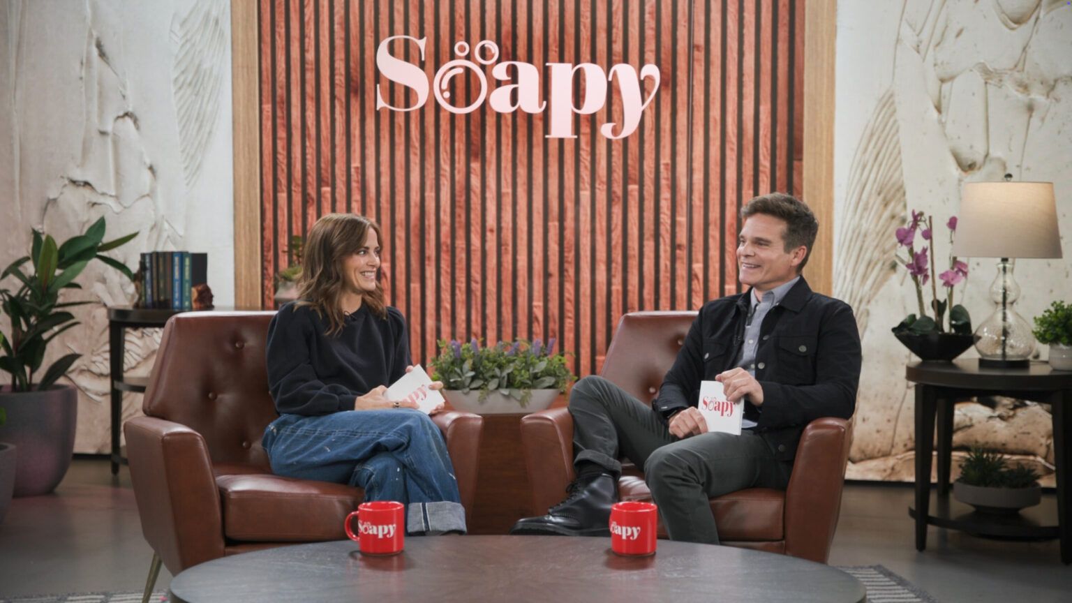 Rebecca Budig & Greg Rikaart Explain Idea Behind ‘Soapy’ Podcast, Shares “Love and Reverence, and Respect” For Genre Rebecca Budig, Greg Rikaart, Soapy Hosted by Rebecca Budig and Greg Rikaart, Podcast